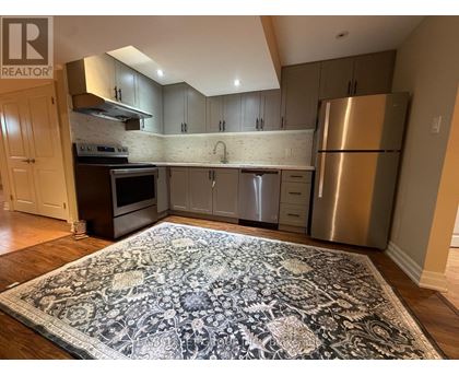 A kitchen with a rug on the floor and a refrigerator on the right.