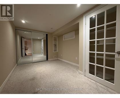 A spacious room with a white door and a mirror on the wall.