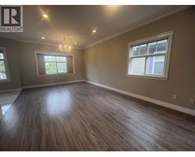 A room with wooden flooring and a chandelier.