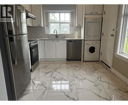 A kitchen with a marble floor and white cabinets.