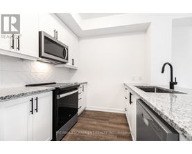 A kitchen with white cabinets and a granite countertop.