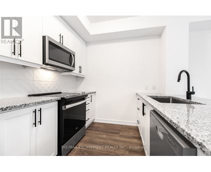 A kitchen with white cabinets and a granite countertop.