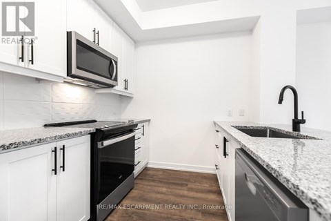A kitchen with white cabinets and a granite countertop.