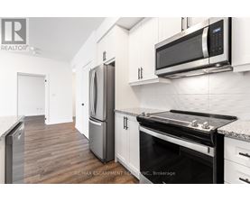 A modern kitchen with a stainless steel refrigerator and microwave.