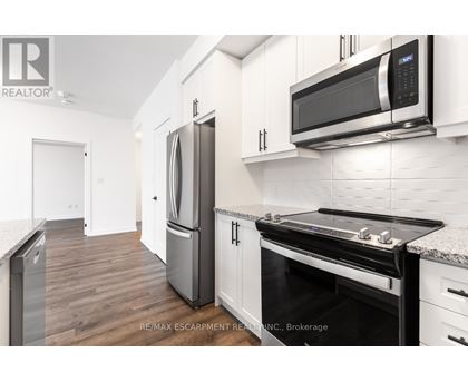 A modern kitchen with a stainless steel refrigerator and microwave.