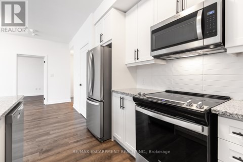 A modern kitchen with a stainless steel refrigerator and microwave.