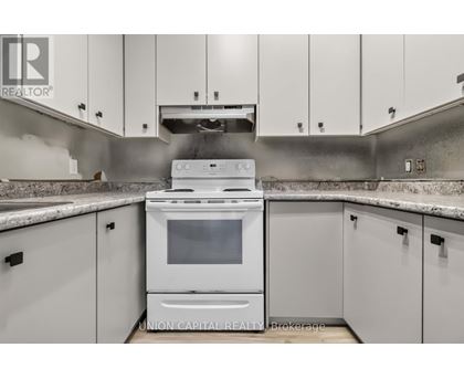 A white oven is in a kitchen with white cabinets.