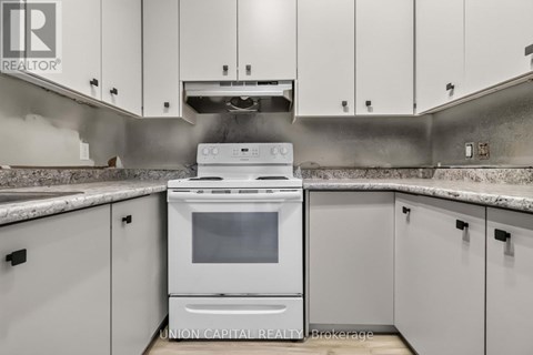 A white oven is in a kitchen with white cabinets.