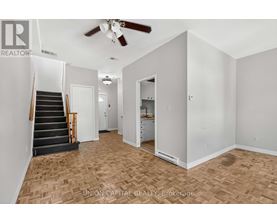 A room with a staircase and a ceiling fan.