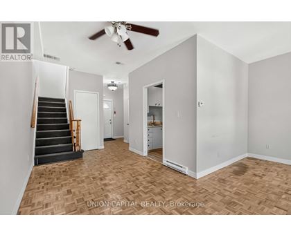 A room with a staircase and a ceiling fan.