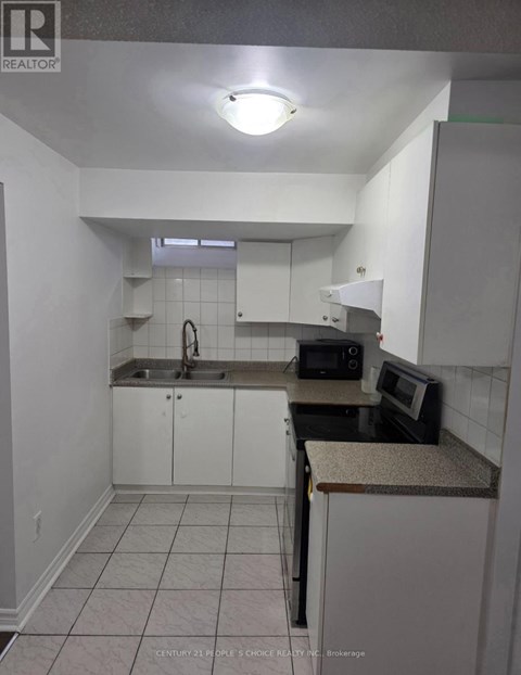 A kitchen with white cabinets and a granite counter.