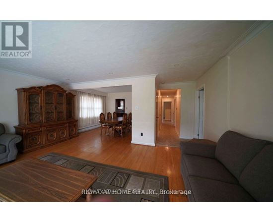 A living room with a brown rug and a brown couch.