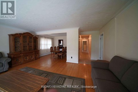 A living room with a brown rug and a brown couch.