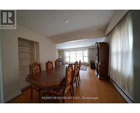A dining room with a wooden table and chairs.