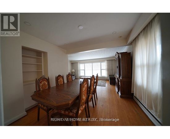 A dining room with a wooden table and chairs.