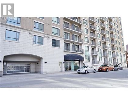 A building with a garage and a car parked in front of it.