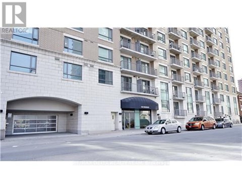 A building with a garage and a car parked in front of it.