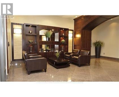 A living room with a brown leather couch and a wooden cabinet.