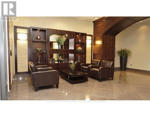 A living room with a brown leather couch and a wooden cabinet.