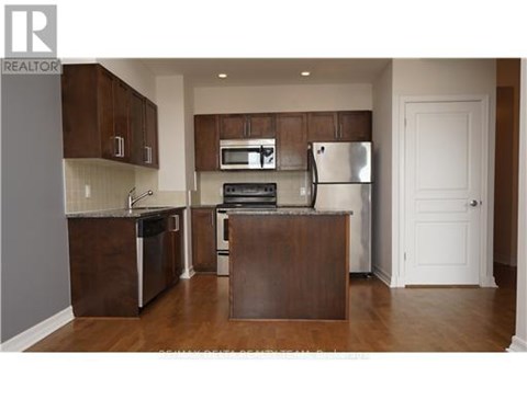 A kitchen with brown cabinets and stainless steel appliances.