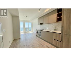 A spacious kitchen with wooden cabinets and a view of the ocean.