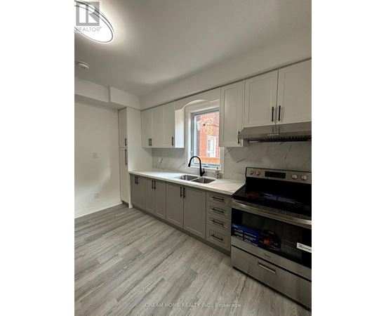 A kitchen with a stove top oven and a sink.