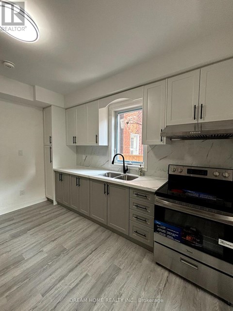 A kitchen with a stove top oven and a sink.