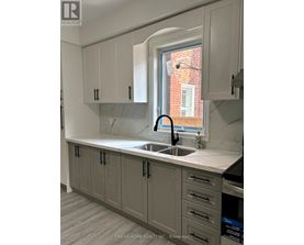 A kitchen with grey cabinets and a white countertop.