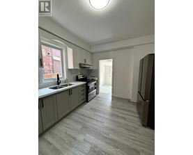 A kitchen with a sink, stove, and refrigerator.