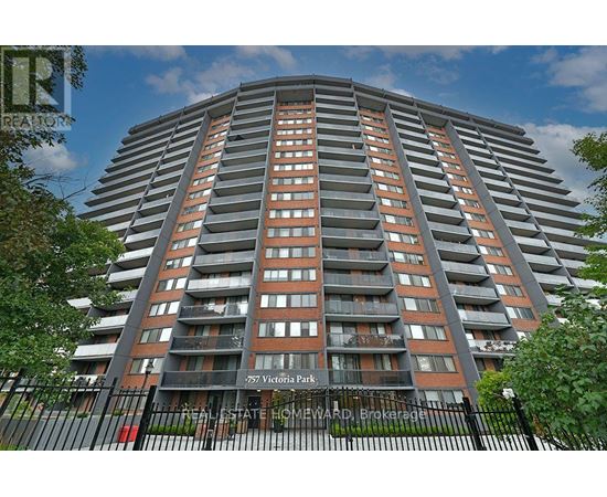 A tall residential building with balconies and a black fence in front.