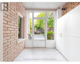 A white door with a glass window is open to a backyard.