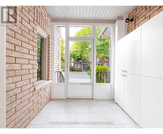A white door with a glass window is open to a backyard.