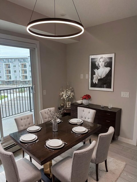 A dining room with a table set for six and a chandelier hanging from the ceiling.