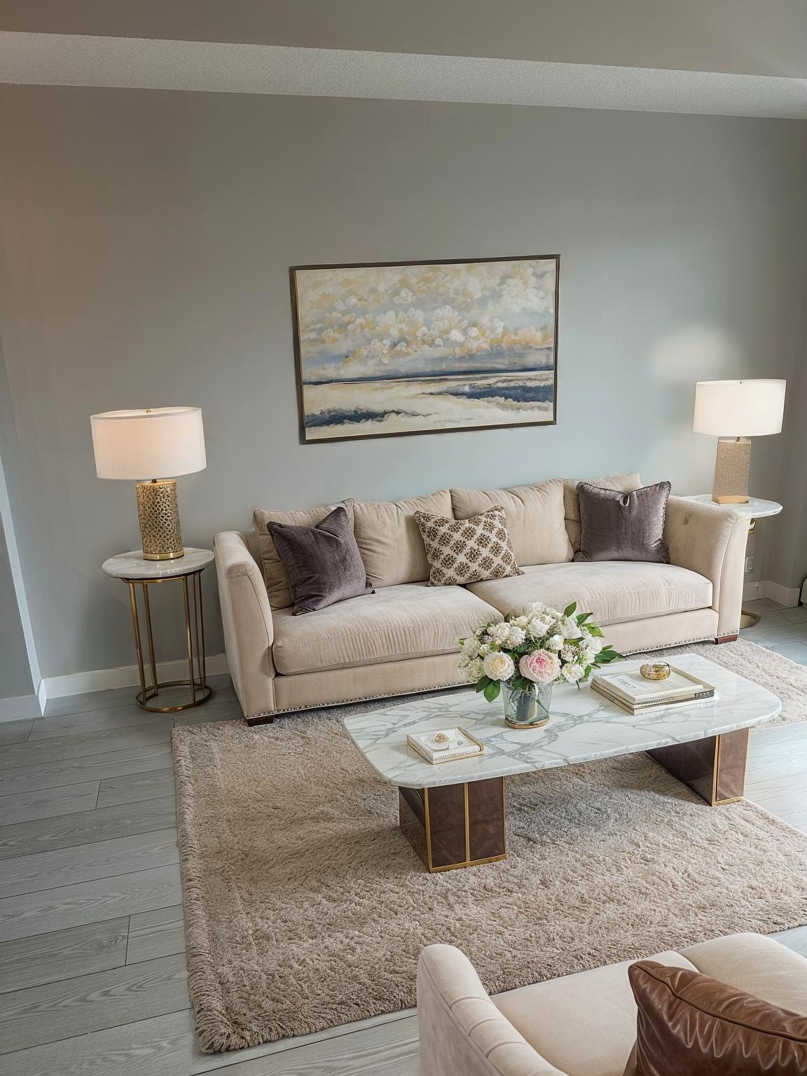 A living room with a beige couch, a coffee table, and two lamps.