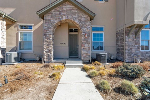 A house with a stone archway entrance and a grey door.