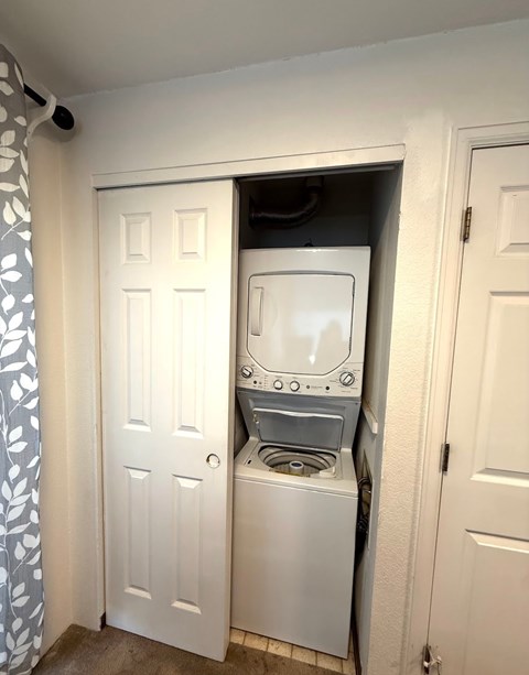 A washing machine is built into a wall in a small room.