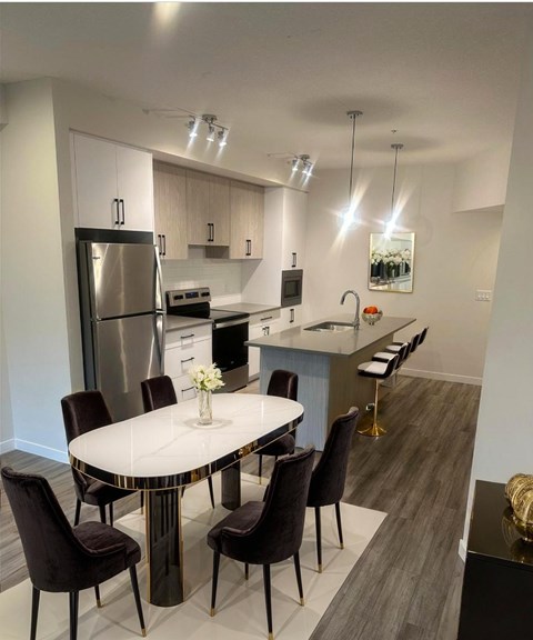 A modern kitchen with a dining table set for four.