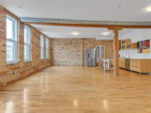 A room with wooden floors and exposed brick walls.