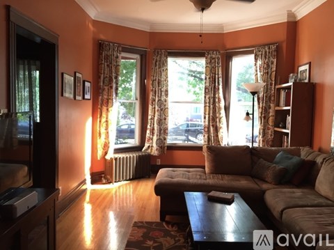 A living room with a brown couch and a ceiling fan.