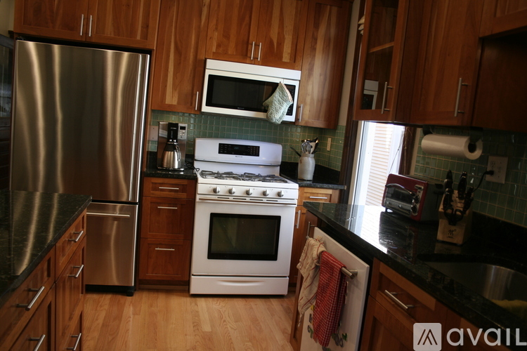 A kitchen with wooden cabinets and a stainless steel refrigerator.