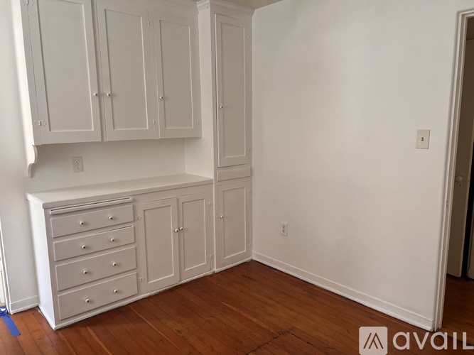 A room with white cabinets and drawers is available for rent.