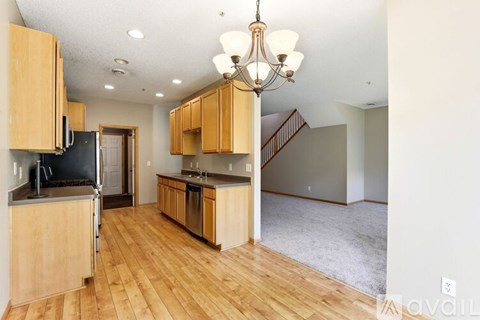 A kitchen with wooden cabinets and a black refrigerator.