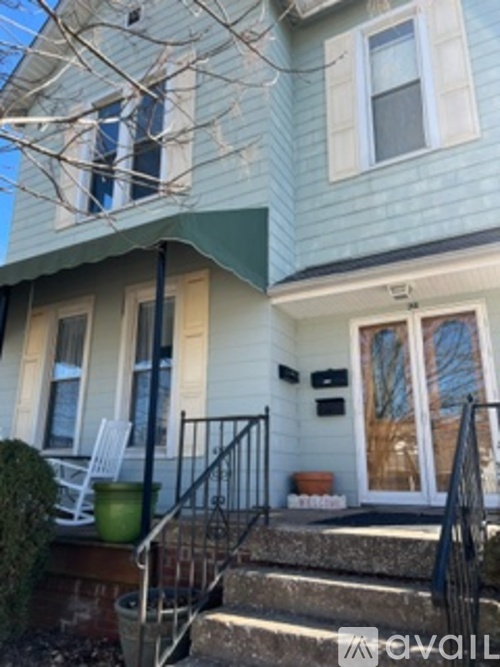 A house with a green awning and a white door.