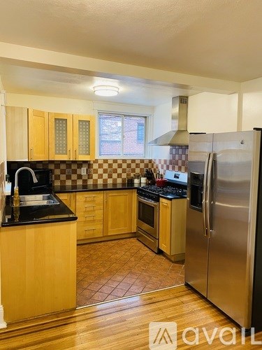 A kitchen with wooden cabinets and a black countertop.