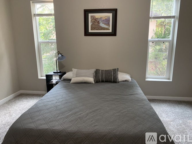 A bedroom with a large bed and a framed picture on the wall.