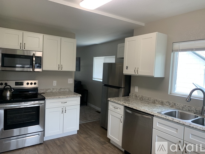 A kitchen with white cabinets and a granite countertop.