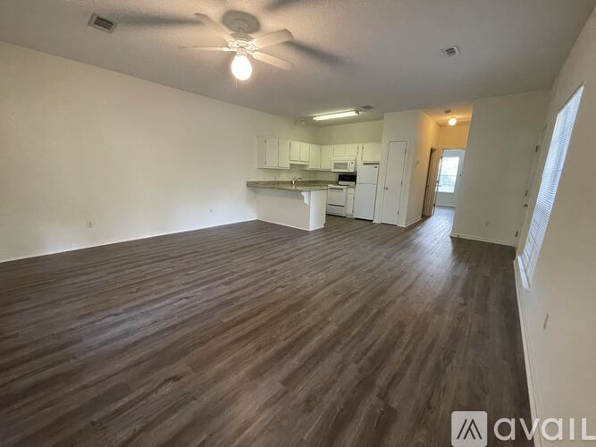 A room with wooden flooring and a ceiling fan.