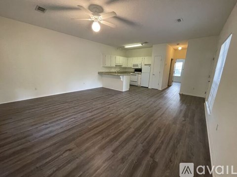 A room with wooden flooring and a ceiling fan.