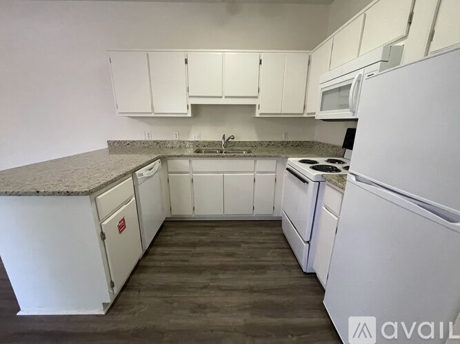 A kitchen with white appliances and cabinets.