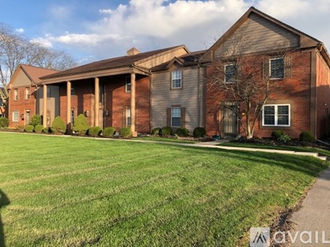 A large brick house with a lawn in front.